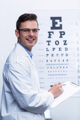 Optometrist writing on clipboard