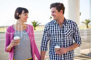 Couple with coffee cups walking together