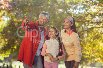 Grandmother pointing while standing with daughter and granddaugh