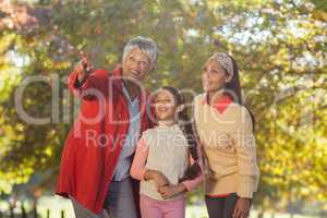 Grandmother pointing while standing with daughter and granddaugh