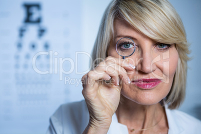 Female optometrist looking through magnifying glass