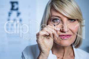 Female optometrist looking through magnifying glass