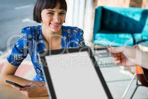 Smiling woman receiving her credit card in coffee shop