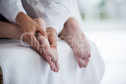 Senior man receiving foot massage from physiotherapist