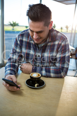 Man using his mobile phone in the coffee shop