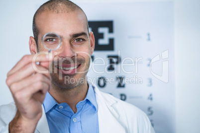 Male optometrist looking through magnifying glass