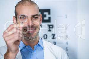 Male optometrist looking through magnifying glass