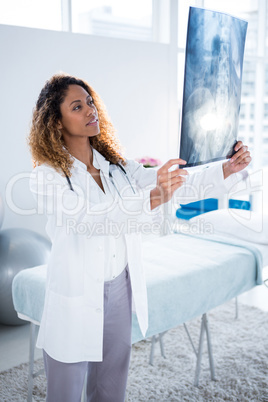 Physiotherapist holding spine x-ray of patient