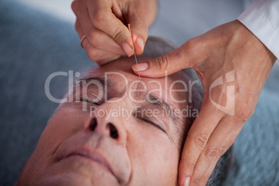 Senior man receiving head massage from physiotherapist