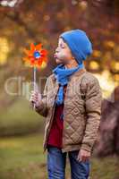 Boy blowing pinwheel at park