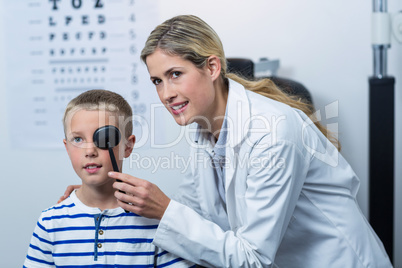 Female optometrist examining young patient with medical equipmen