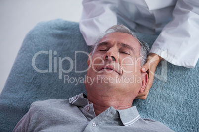 Senior man receiving neck massage from physiotherapist