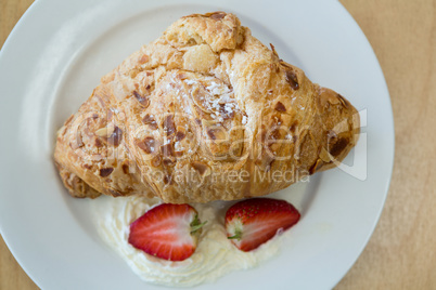Close-up of croissant and strawberry on plate