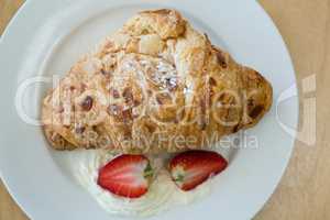 Close-up of croissant and strawberry on plate