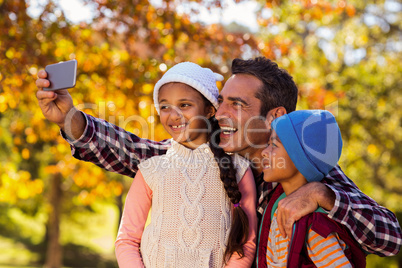 Happy father taking selfie with children at park