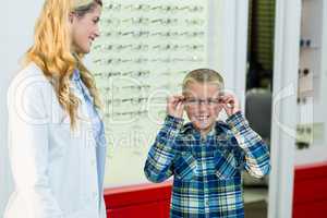 Female optometrist prescribing spectacles to young patient