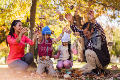 Cheerful family playing with autumn leaves