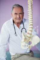 Portrait of physiotherapist examining a spine model