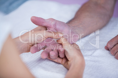 Physiotherapist giving hand massage to a patient