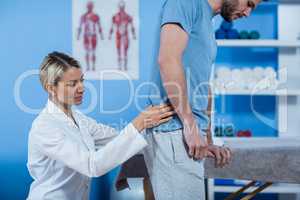 Physiotherapist examining mans back