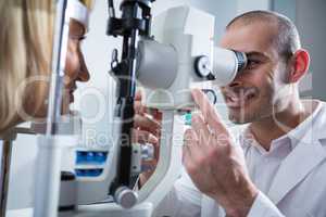 Optometrist examining female patient on slit lamp