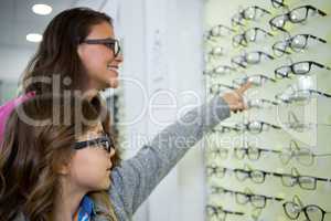 Mother and daughter selecting spectacles from display