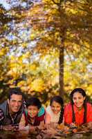 Portrait of happy family lying on field at park