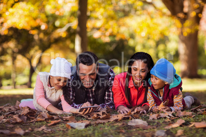 Happy family looking at mobile phone at park