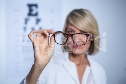 Female optometrist holding spectacles