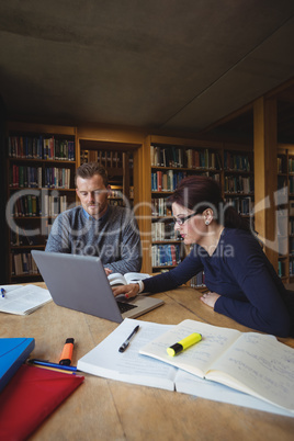 Mature students working together in college library
