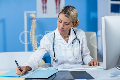 Physiotherapist writing a medical report