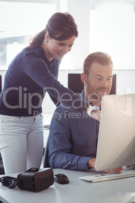 Teacher assisting mature student in computer room