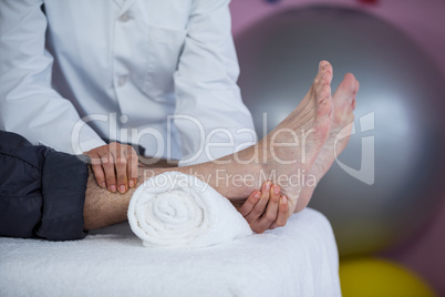 Senior man receiving foot massage from physiotherapist