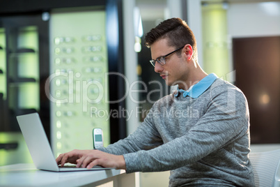 Customer using laptop in optical store