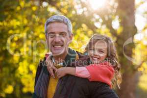 Father piggybacking daughter at park