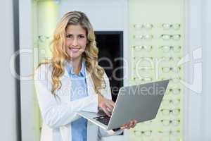 Optometrist using laptop in ophthalmology clinic