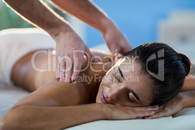 Male physiotherapist giving back massage to female patient