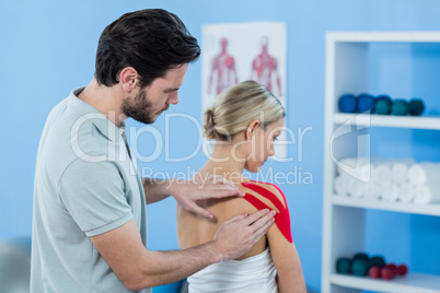 Physiotherapist sticking tape on female patient