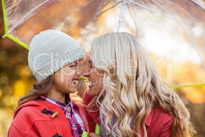 Mother and daughter rubbing noses at park