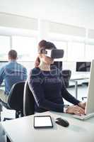 Mature student in virtual reality headset using computer