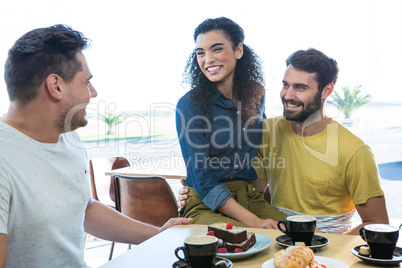 Friends interacting with each other in coffee shop