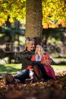 Romantic couple sitting under tree at park