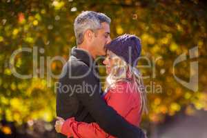 Couple hugging at park during autumn