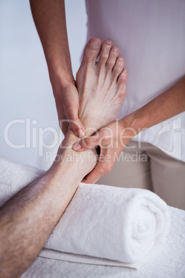 Physiotherapist giving foot massage to a patient