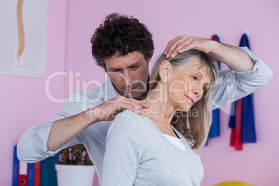 Physiotherapist giving neck massage to female patient