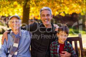 Man with father and son sitting at park