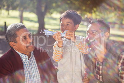 Cheerful boy with toy airplane by family
