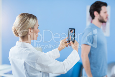 Physiotherapist clicking photo of a male patient