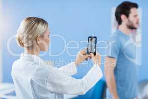 Physiotherapist clicking photo of a male patient