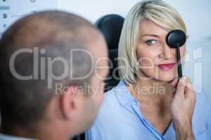 Optometrist examining female patient with medical equipment